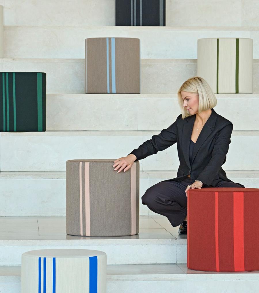 Savak NU: woman arranging striped upholstered cubes on stepped seating