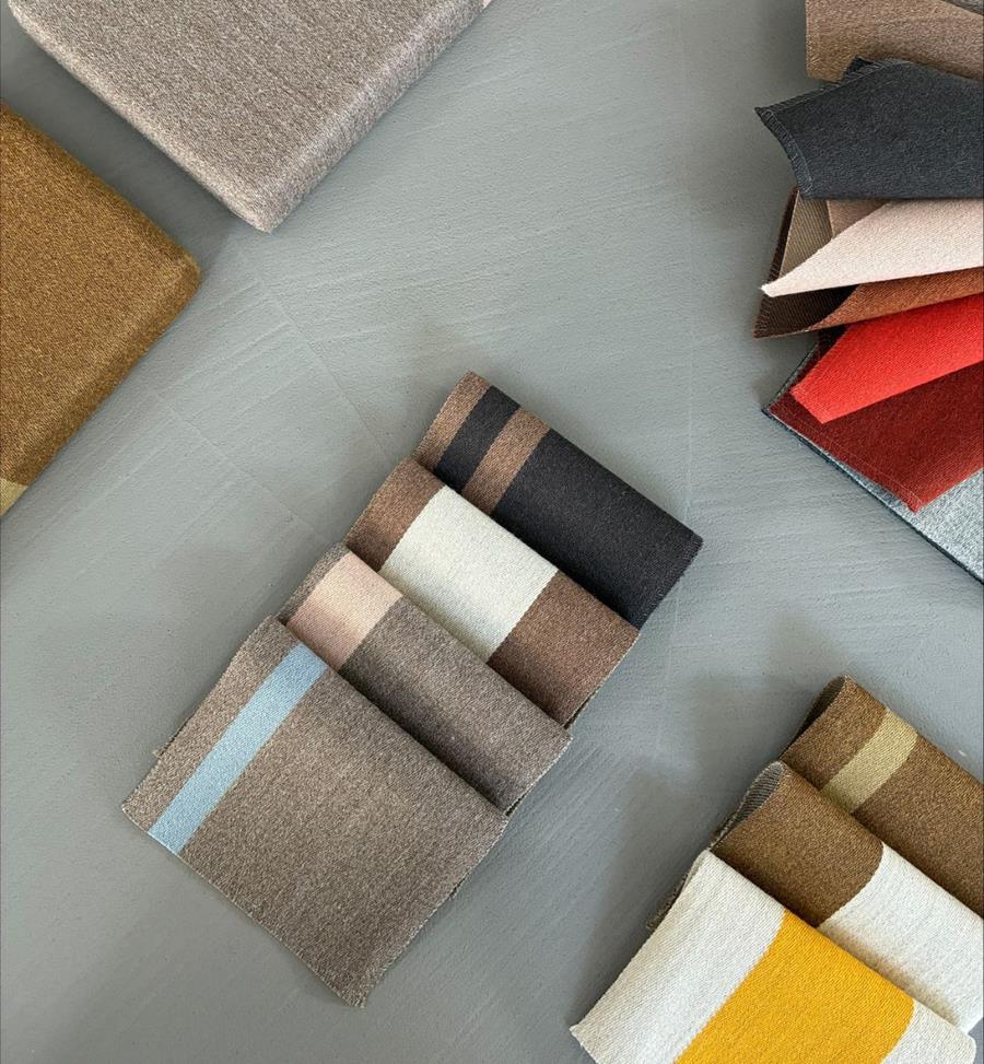 Gabriel fabric samples in browns, creams and oranges laid out on a grey floor