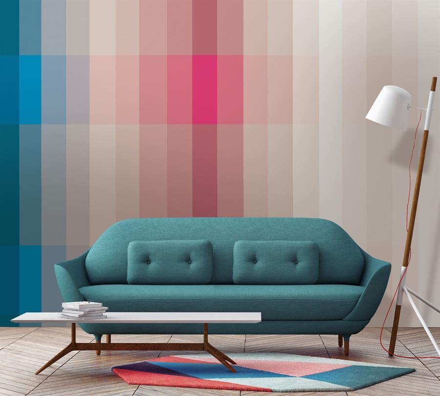 A wall of pink and blue colour blocks behind a teal sofa