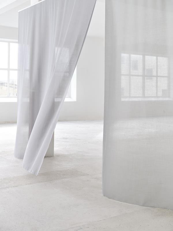 Salt semi-transparent curtains hanging in a white room