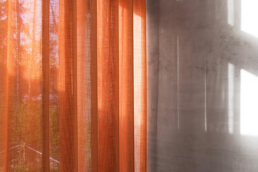 Orange sheer curtains backlit by the sun
