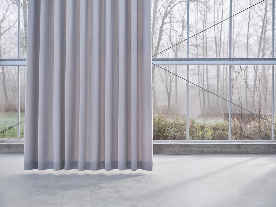 Full-length grey curtain drawn across a glass wall