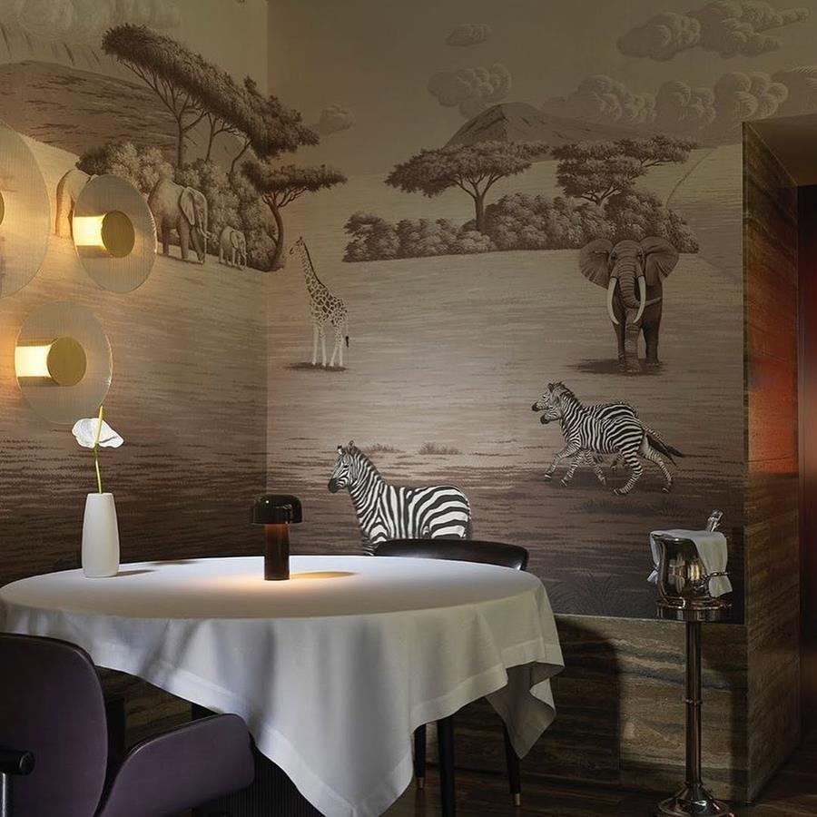 Dining room with a hand-painted mural of acacia trees, giraffes and zebras
