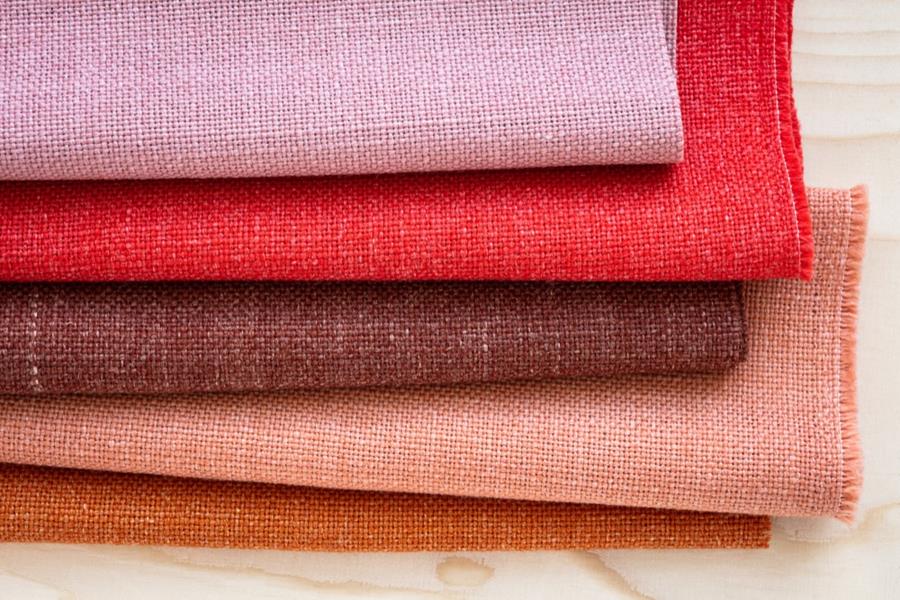Folded Svensson upholstery fabrics in pink, red and orange
