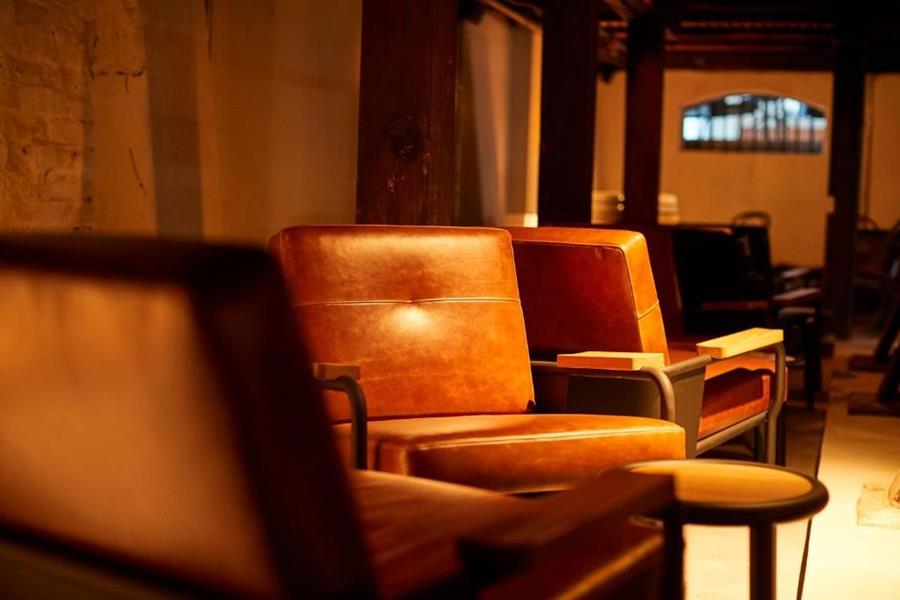 Tan leather armchairs in a dimly lit lounge