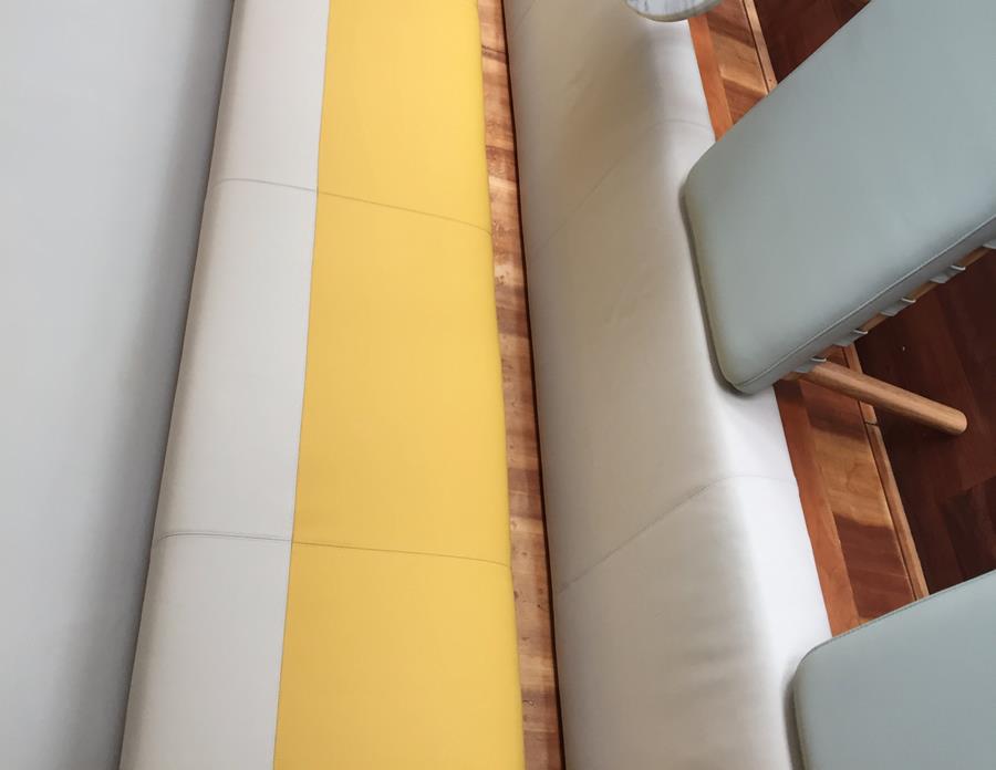 A banquette in yellow and stone leather