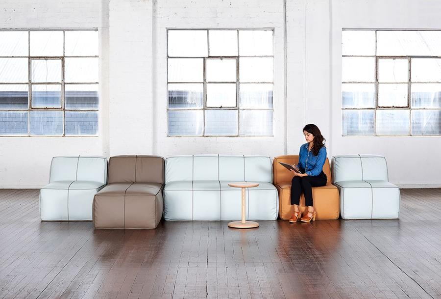 A bright office with leather sofas beneath tall windows