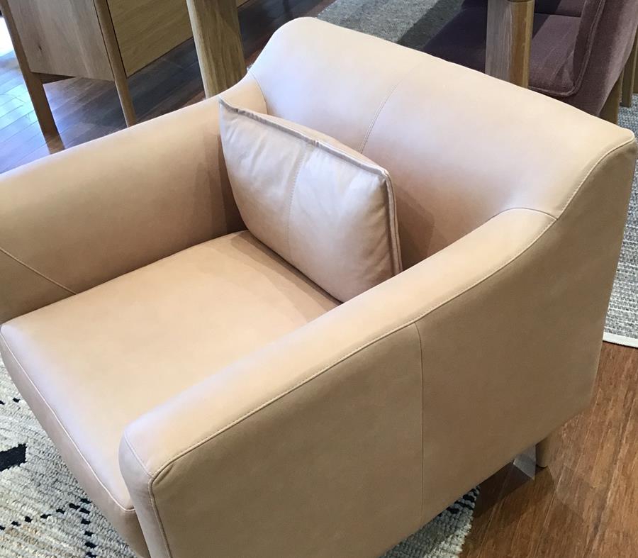 A pale stone leather armchair with a cushion