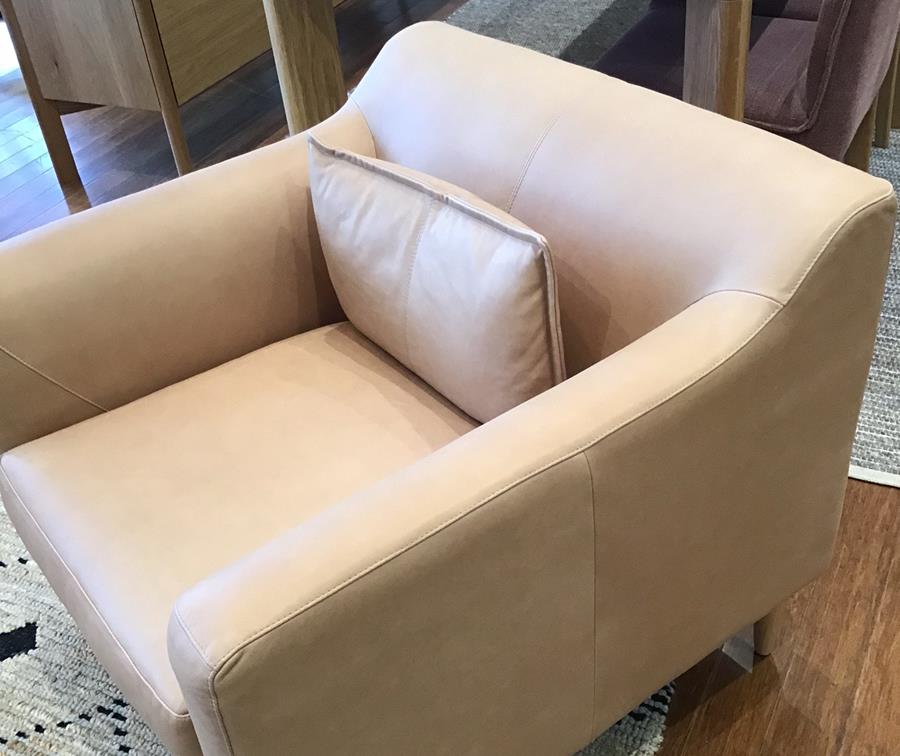 A pale stone leather armchair with a cushion