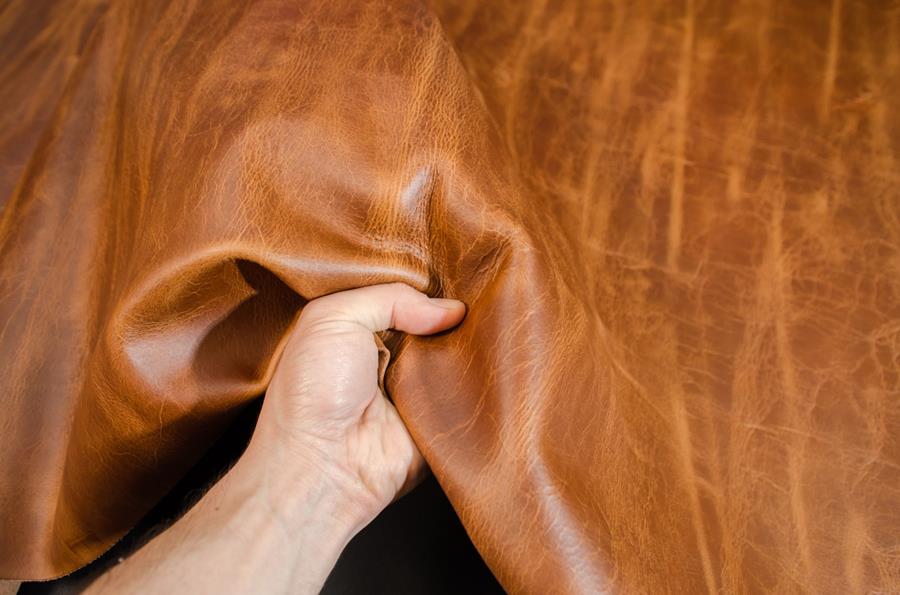 A hand squeezing tan Britannia leather