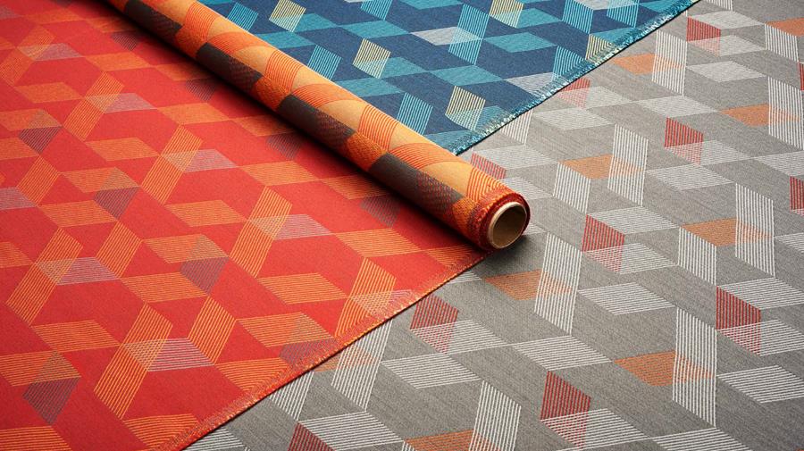 Orange patterned Designtex fabric rolled out across a floor