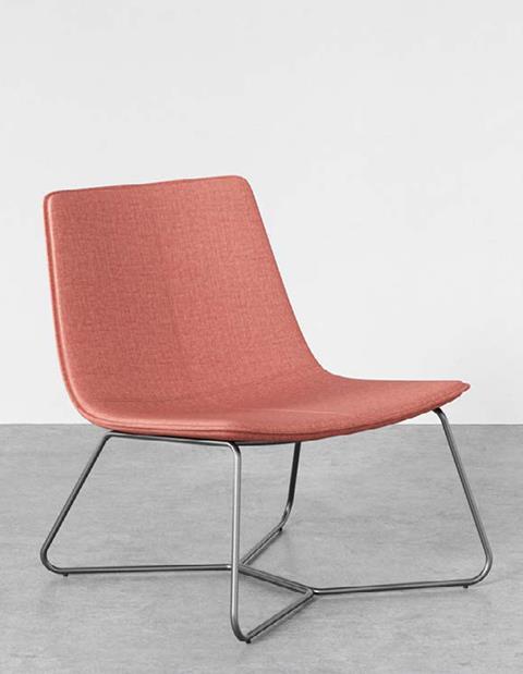 A coral upholstered lounge chair on a sled base