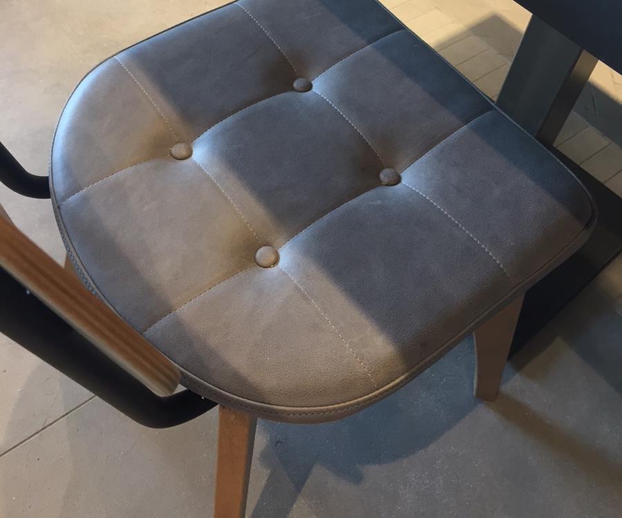 A buttoned seat in grey Castello leather