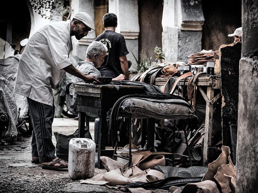 Leather workers at a bench in a workshop
