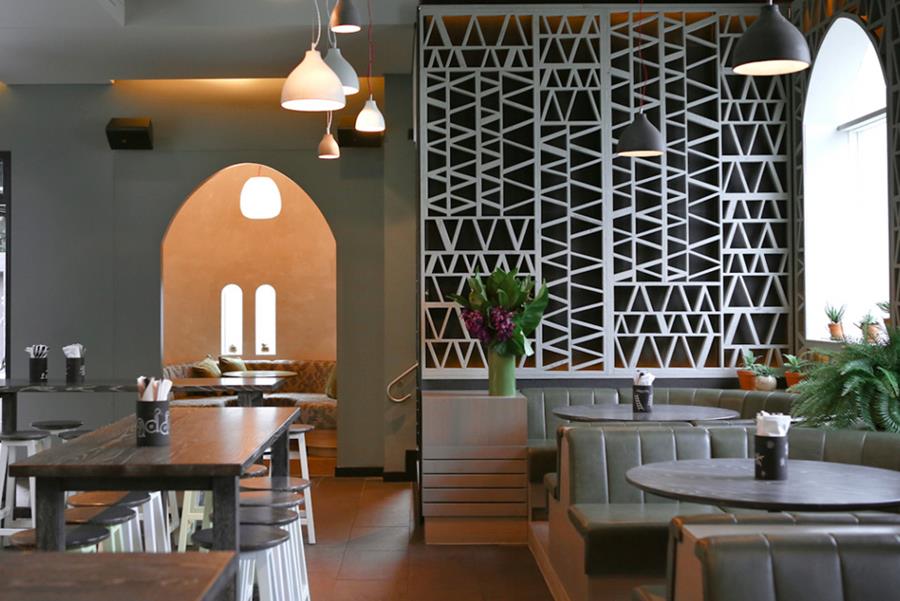 A restaurant with leather banquettes and arched screens