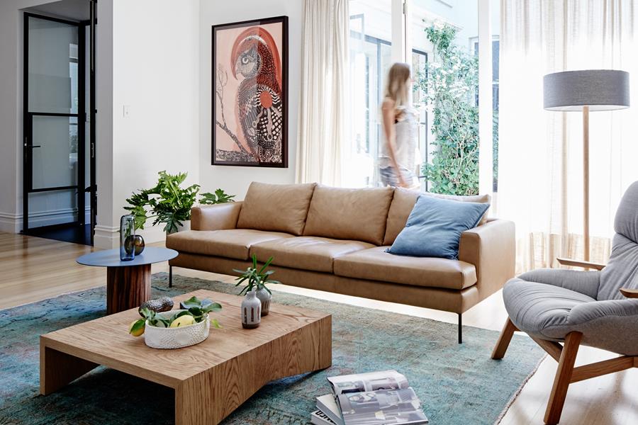 A living room with a tan leather sofa