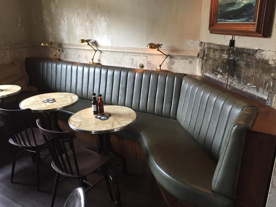 Black leather booths in a dimly lit bar