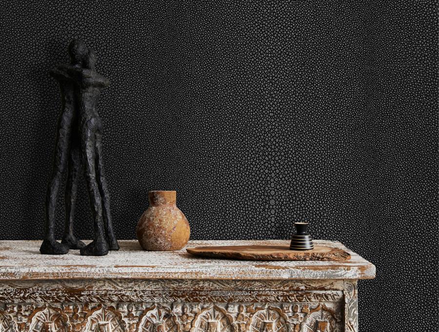 Sculptural objects on a console against black Newmor Shagreen wallcovering