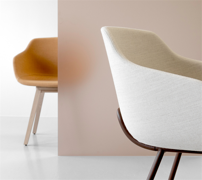 A white shell chair beside a mustard upholstered chair