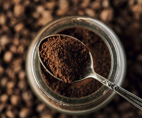 A spoon in a jar of ground coffee