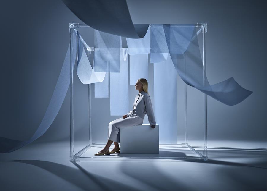 Sheer blue Svensson fabrics suspended around a seated woman