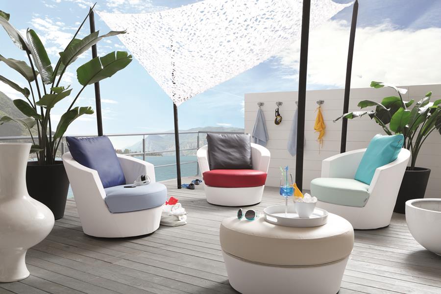 Rooftop terrace with white outdoor lounge chairs and cushions under a shade sail