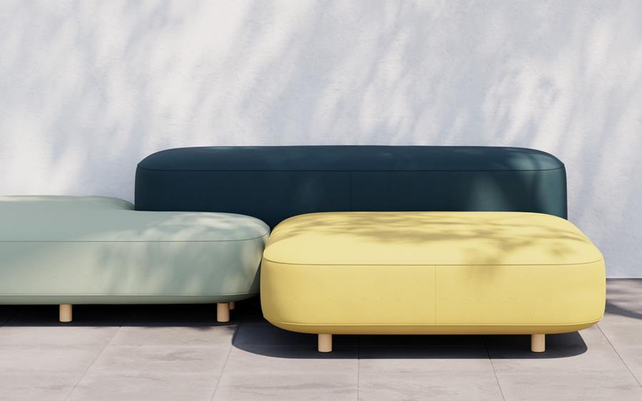 Outdoor sofa and ottoman in deep green and yellow on a terrace