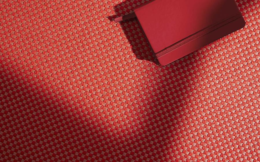 Emblem: coral check outdoor fabric under a red lounge chair