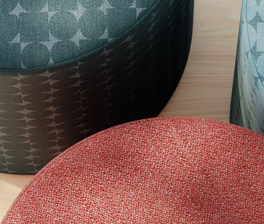 Round stools in a dark patterned and a rust Designtex upholstery