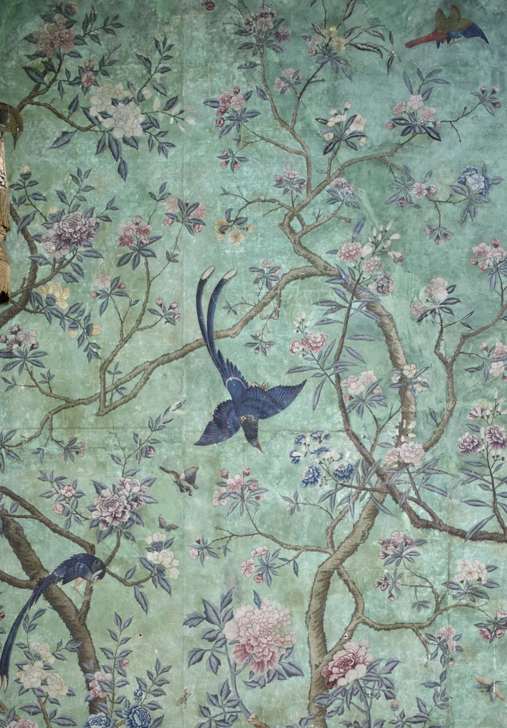 Blue birds among flowering branches, hand-painted on a green ground