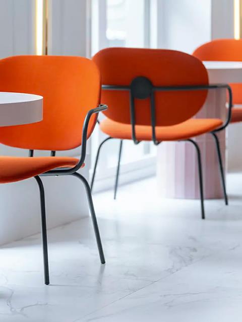 IKONIK Gran Vía, Madrid: orange upholstered chairs on a white marble floor