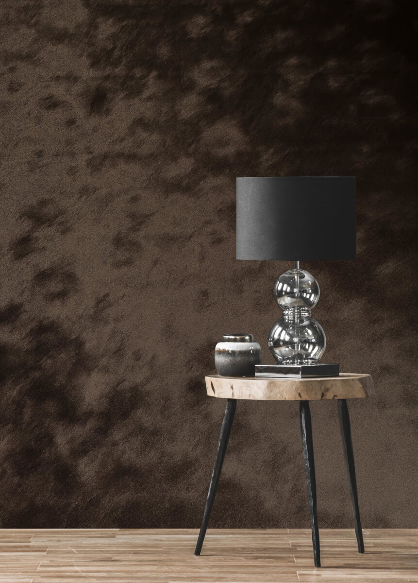 Newmor Peloso: a dark brown embossed wall behind a lamp