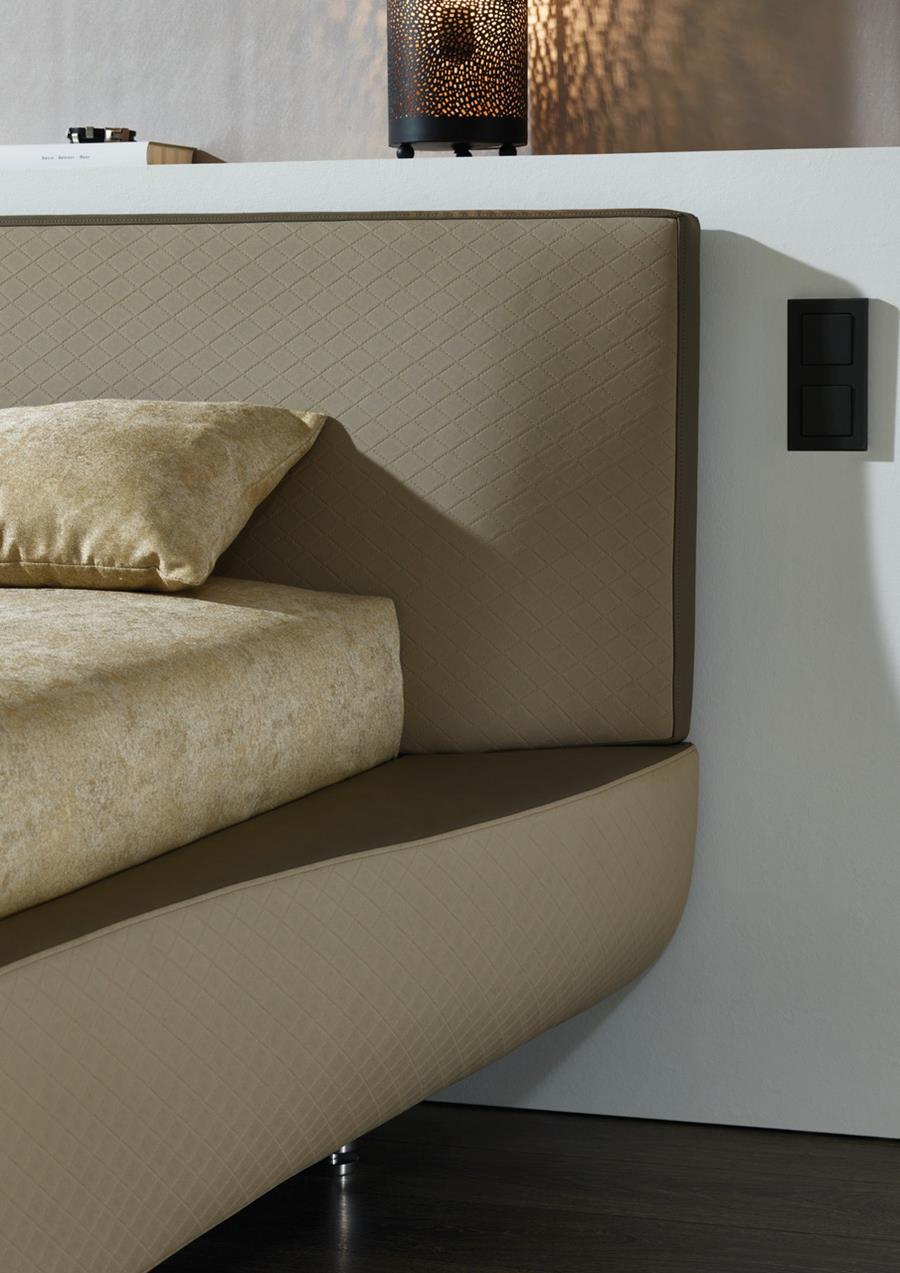 An upholstered bed headboard in taupe skai