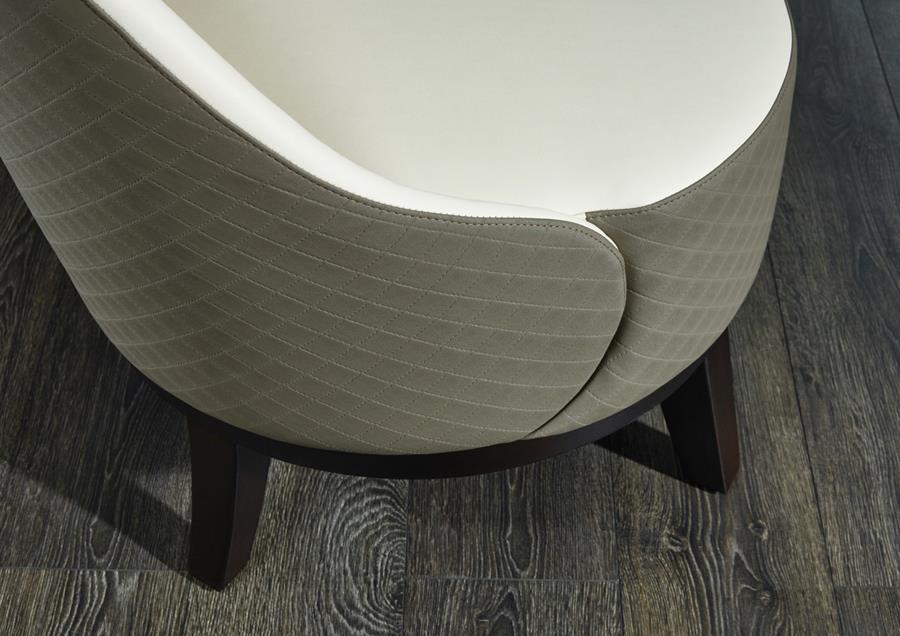 A curved chair in grey-green skai artificial leather