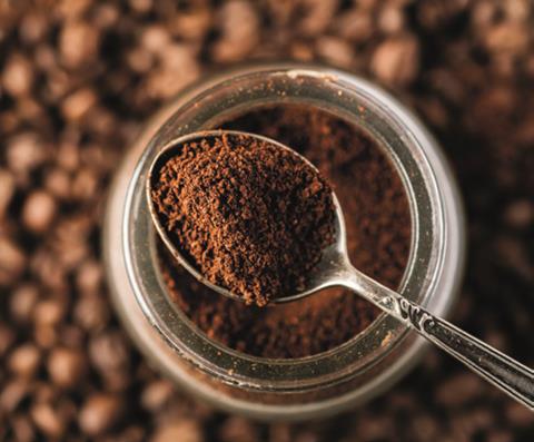 A spoon in a jar of ground coffee