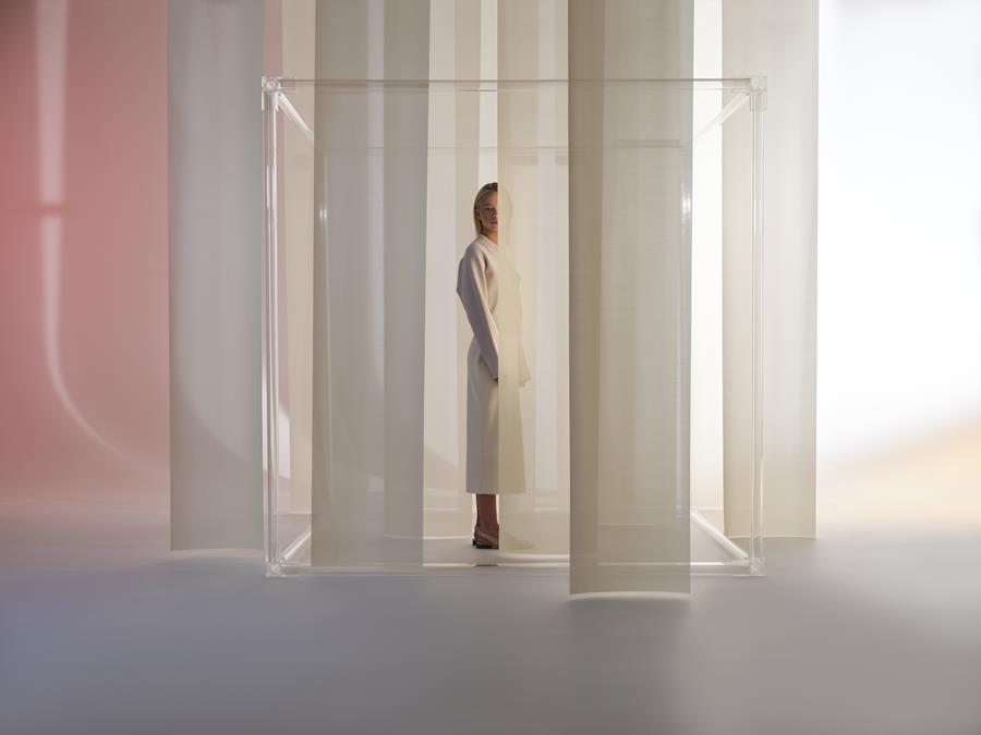 A woman standing among pale translucent Svensson blinds
