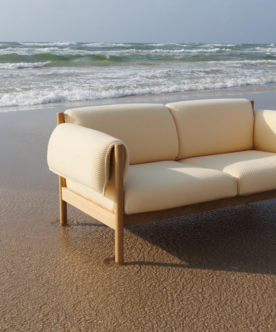 UMI: cream sofa on a beach at the water's edge