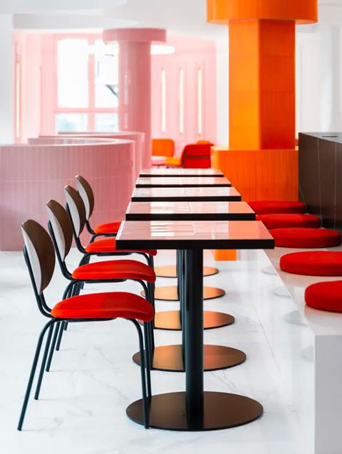 IKONIK Gran Vía, Madrid: long table lined with orange upholstered chairs